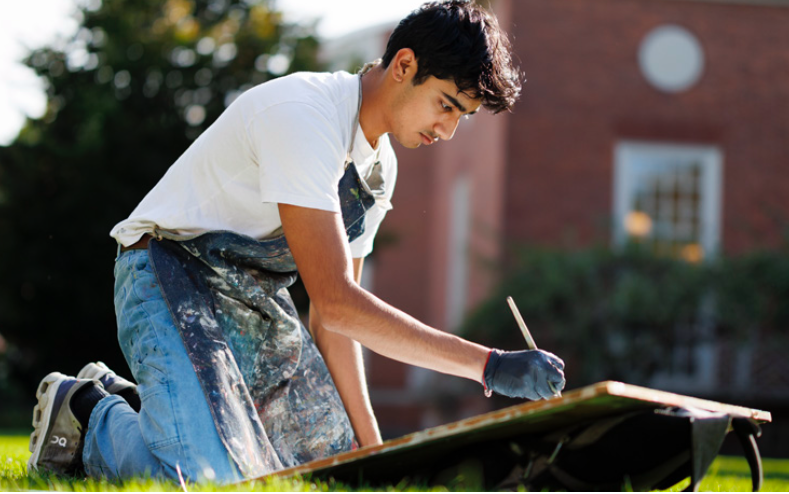 a student painting in Harvard Yard